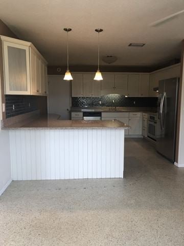 Cocoa house for rent - A kitchen with a white counter and a refrigerator.