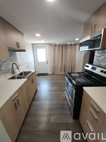 Janesville house for rent - A kitchen with wooden cabinets and a black stove top oven.