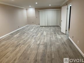 Culver City apartment for rent - A spacious room with wooden flooring and a sliding door.