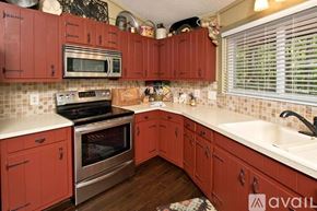 Sky Valley house for rent - A kitchen with red cabinets and a stainless steel oven.