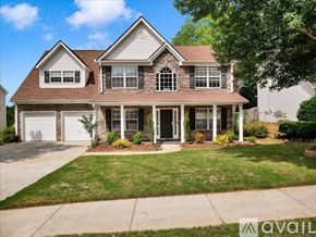 Suwanee house for rent - A house with a brown roof and a white garage door is for sale.