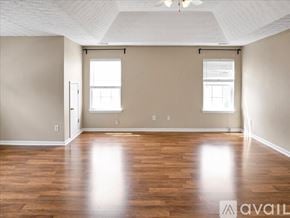 Suwanee house for rent - A spacious room with wooden floors and two windows.