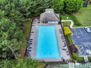 Suwanee house for rent - A large swimming pool surrounded by a deck and trees.