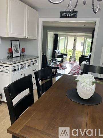 Laconia townhouse for rent - A living room with a black couch and a red and black rug.