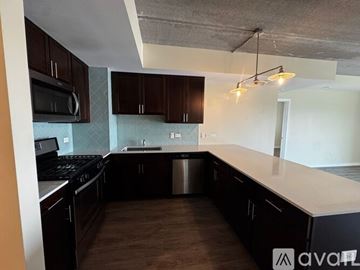 Chicago apartment for rent - A kitchen with dark brown cabinets and a stainless steel dishwasher.