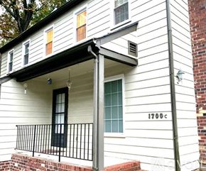 Richmond apartment for rent - A white house with black railings and a black door.