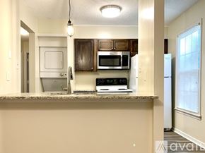 Richmond apartment for rent - A kitchen with a white fridge, microwave, and oven.