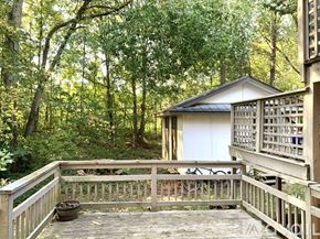 Richmond apartment for rent - A small building with a gabled roof is surrounded by a wooden deck and a forest.