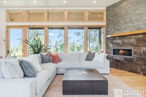 Kalispell house for rent - A modern living room with a fireplace and a large window.