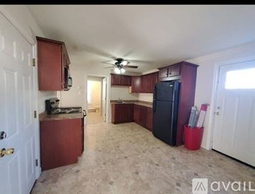 Southbridge apartment for rent - A kitchen with a black refrigerator and wooden cabinets.