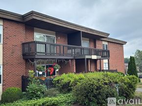 Seymour condo for rent - A red brick building with a balcony and plants in front.