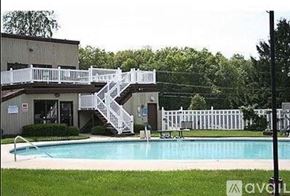 Seymour condo for rent - A pool with a white fence and a building with a white staircase.