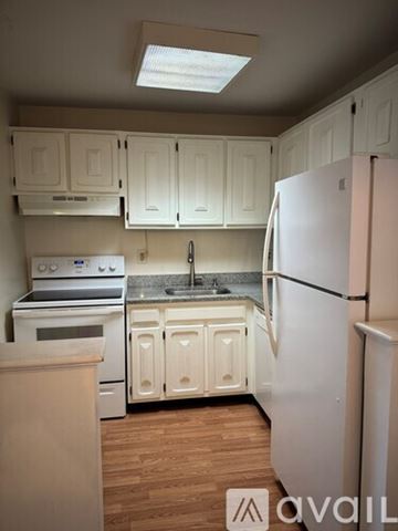 Seymour condo for rent - A kitchen with white cabinets and a white refrigerator.