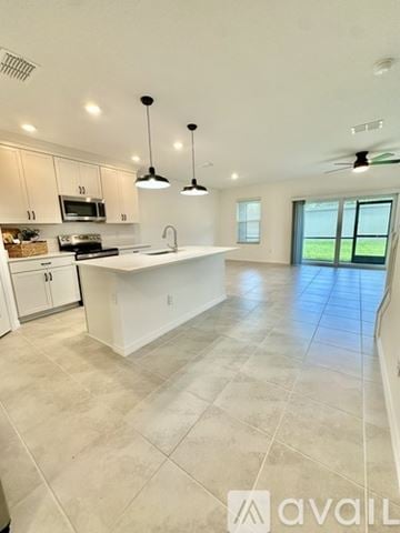 Palmetto house for rent - A kitchen with white cabinets and a large island.