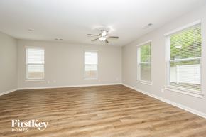 Antioch house for rent - A spacious room with wooden flooring and a ceiling fan.