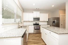 Antioch house for rent - A kitchen with white cabinets and granite countertops.