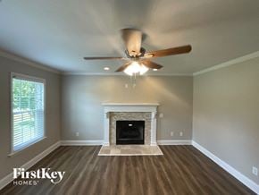 Advance house for rent - A room with a fireplace and a ceiling fan.