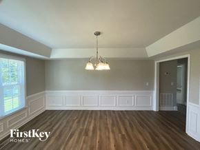 Advance house for rent - A room with wooden floors and a chandelier hanging from the ceiling.
