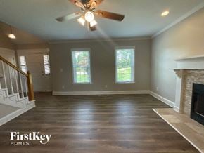 Advance house for rent - A spacious living room with a fireplace and a ceiling fan.