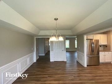 Advance house for rent - A large open kitchen and living room with wood floors and white walls.