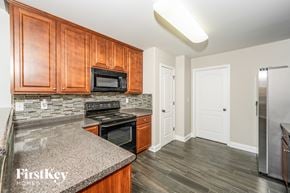 Maylene house for rent - A kitchen with wooden cabinets and a granite countertop.