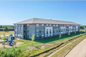 Waterloo apartment for rent - A large grey building with a playground in front of it.