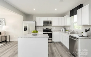 Charlotte house for rent - A modern kitchen with white cabinets and a large island.