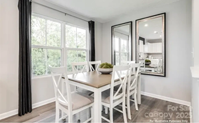 Charlotte house for rent - A dining room with a table and chairs and a large mirror on the wall.