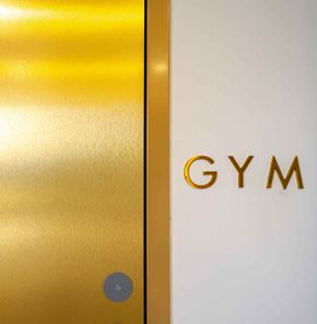 Dania Beach apartment for rent - A white door with a gold Gym sign on it.