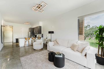 Dania Beach apartment for rent - A modern living room with a white couch and a grey rug.