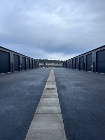Post Falls house for rent - A long row of dark blue garage doors on either side of a concrete walkway.
