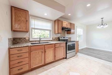 Jacksonville house for rent - A kitchen with wooden cabinets and a granite countertop.