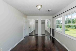 Jacksonville house for rent - A spacious room with wood floors and a large window.