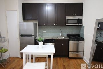 Chicago apartment for rent - A kitchen with a white table and black cabinets.