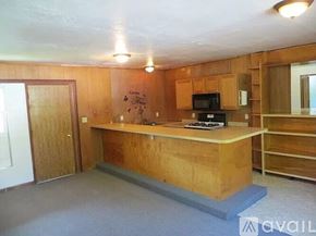 Fall River Mills apartment for rent - A kitchen with wooden cabinets and a microwave.