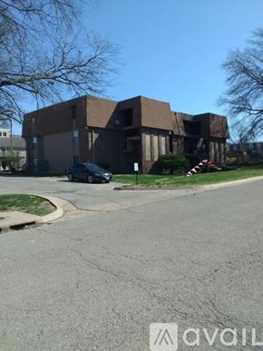 Topeka apartment for rent - A black car is parked in front of a brown building.