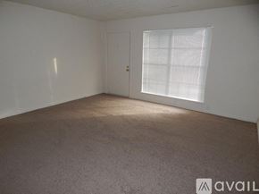 Topeka apartment for rent - A room with a carpeted floor, a door, and a window with blinds.