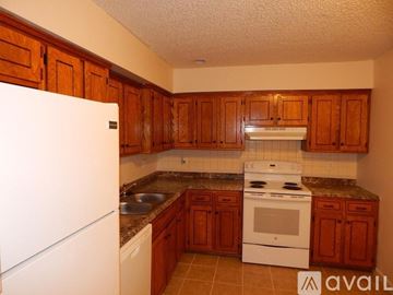Topeka apartment for rent - A kitchen with wooden cabinets and a white refrigerator.