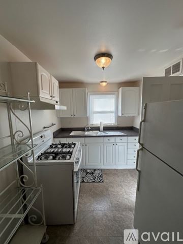 Oklahoma City house for rent - A kitchen with white cabinets and a white fridge.