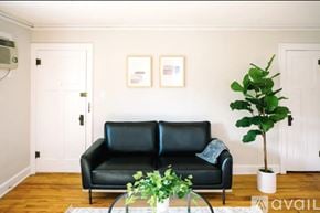 Des Moines apartment for rent - A living room with a black leather couch, a television, and a coffee table.
