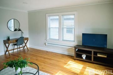 Des Moines apartment for rent - A bedroom with a white bed and a grey blanket.
