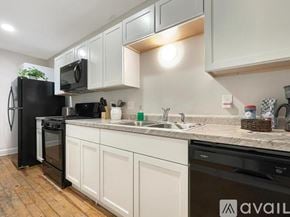 Des Moines apartment for rent - A kitchen with a black fridge and white cabinets.