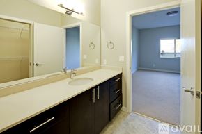 Mercer Island apartment for rent - A bathroom with a sink, mirror, and a door leading to another room.