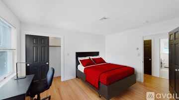 Waltham house for rent - A bedroom with a red bed and a black desk.