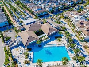 Doral townhouse for rent - A large house with a pool in the foreground and smaller houses in the background.