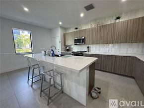Doral townhouse for rent - A modern kitchen with a white countertop and a window.