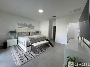 Doral townhouse for rent - A bedroom with a large bed and a bench in the middle of the room.
