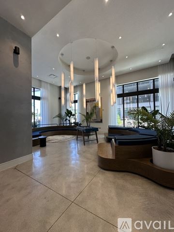 Oakland Park apartment for rent - A spacious living room with a curved wooden bench and a large window.