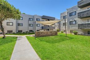 Mesa apartment for rent - A modern building with a grassy area in front.