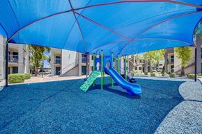 Phoenix apartment for rent - A playground with a blue canopy and a green slide.